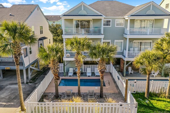 A multi-story hotel with balconies, a swimming pool, and palm trees. - Ocean View Duplex Near Surfside Pier - 5 Bedrooms, Sleeps 14 (Surfside Beach)