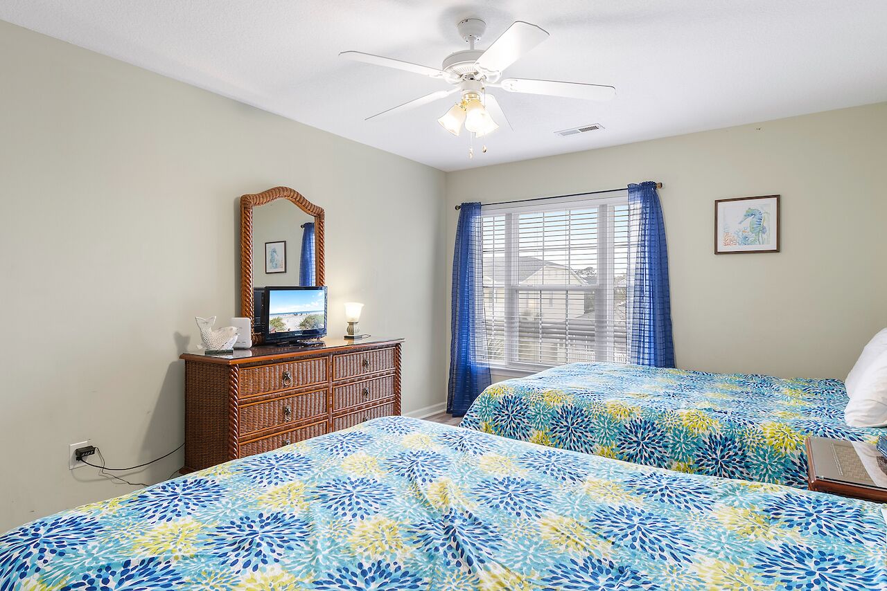 Drift off in comfort with two plush beds, coastal decor, and gentle ceiling fan breezes to keep you cool.