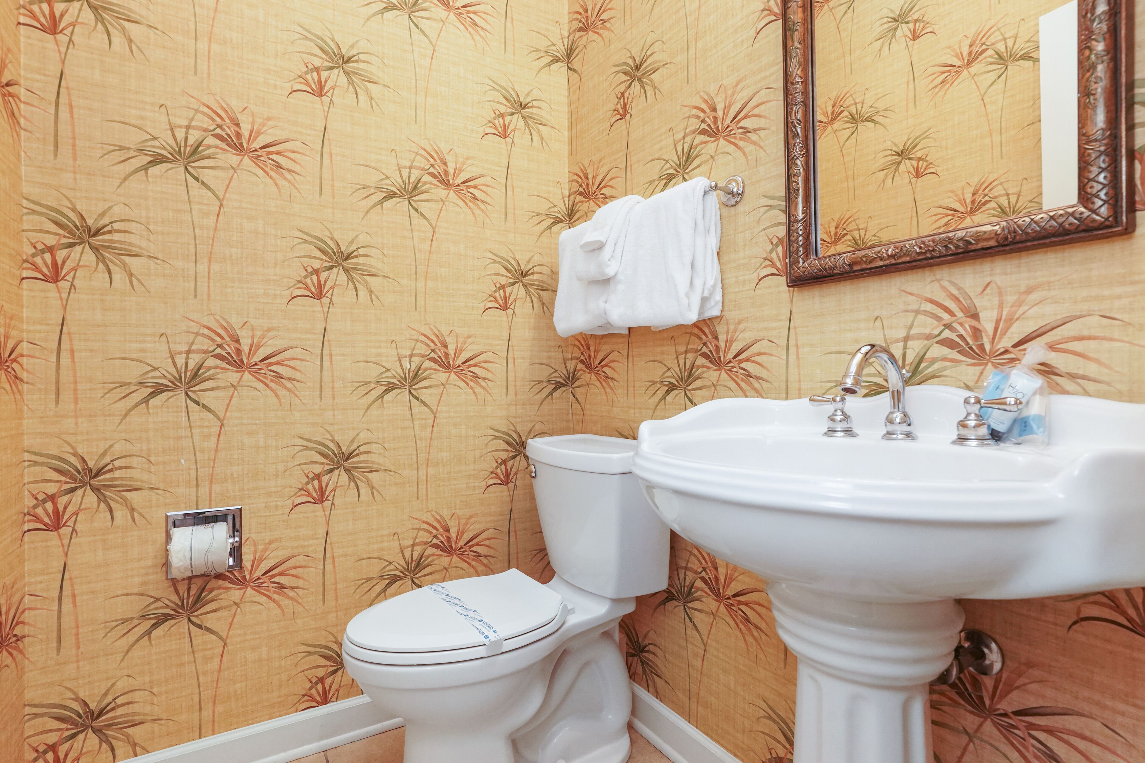Un baño con inodoro, lavamanos y espejo.