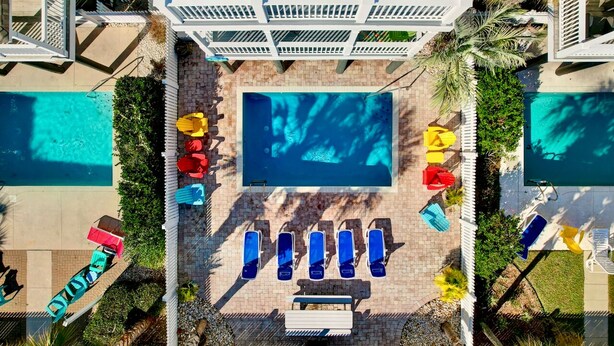 A rooftop pool area with multiple sun loungers and a central pool. - Walk to Beach Surfside Beach Home w/ Private Pool & Linens (Surfside Beach)
