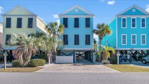 A row of three-story houses with a covered walkway in between. - Walk to Beach Surfside Beach Home w/ Private Pool & Linens (Surfside Beach)