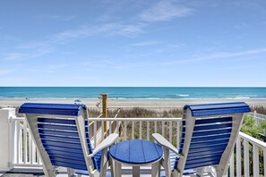 A deck with two blue Adirondack chairs and a small table, overlooking a beach with the ocean in the background. - 5-Bedroom Home Sleeps 12 w/ Private Beach Access (Garden City Beach)