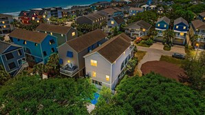 A residential area with houses, a swimming pool, and a view of the ocean at sunset. - Walk to Beach Home w/ Private Pool & New Amenities for Families (Surfside Beach)