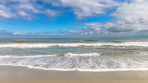 Ein Strand mit Wellen und blauem Himmel.