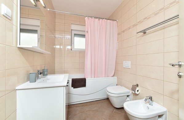 A bathroom with a bathtub, toilet, and sink. - Apartment 396/902 (Istria - Medulin), 300m from the beach (Medulin)