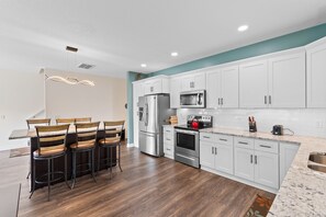 Enjoy cooking in this well-equipped kitchen with a refrigerator, microwave, oven, and sink.