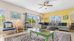 A living room with a ceiling fan, a sofa set, a coffee table, and a patterned rug. - 5-Bedroom Home w/ Pool Near Surfside Beach (Surfside Beach)