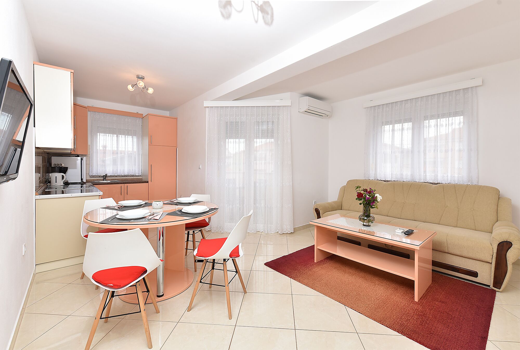 A compact living space with a dining area, kitchenette, and a sofa.