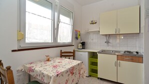 A compact kitchen with a dining table, a coffee machine, and a sink. - Apartment 405/917 (Istria - Medulin), 300m from the beach (Medulin)