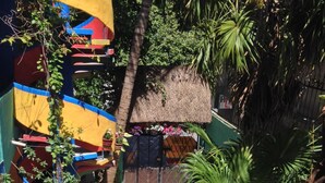 A colorful outdoor area with a thatched-roof structure, a slide, and a small blue table. - Hotel Colorado Playa Del Carmen (Playa del Carmen)