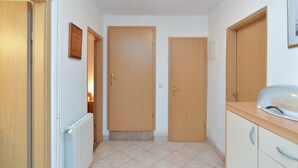 A hallway with two wooden doors, a radiator, and a countertop with a sink. - Apartment 436/1001 (Istria - Valbandon), 750m from the beach (Valbandon)
