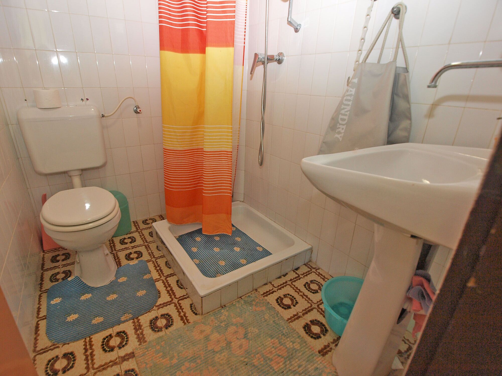 A small bathroom with a toilet, shower, and sink.