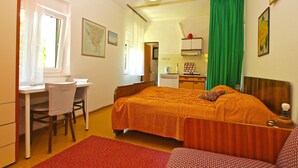 A bedroom with a bed, a desk, a chair, a kitchenette, and a bathroom. - Apartment 461/1081 (Istria - Stinjan), 900m from the beach (Stinjan)