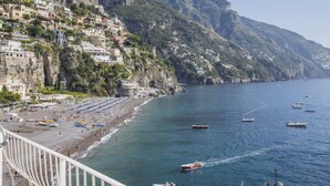 A coastal town with buildings on a hillside, a beach, and boats on the water. - Holidayhome I Delfini Positano (Positano)