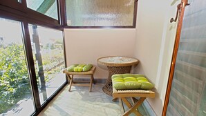 A corner of a room with a large window, a wicker chair with cushions, a small round table with a bowl, and a woven stool. - Apartment 531/1273 (Istria - Stinjan), 700m from the beach (Stinjan)