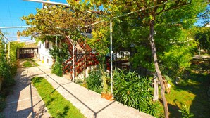 A pathway leading to a building with a red staircase and a pergola covered in vines. - Apartment 531/1273 (Istria - Stinjan), 700m from the beach (Stinjan)