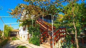 A staircase leading up to a building with a metal railing, surrounded by greenery and a clear blue sky. - Apartment 531/1273 (Istria - Stinjan), 700m from the beach (Stinjan)