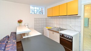 A compact kitchen with a white countertop, yellow cabinets, a built-in oven, and a window with a view. - Apartment 534/1277 (Istria - Stinjan), 500m from the beach (Stinjan)