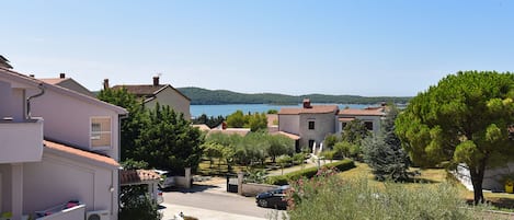 A residential area with houses, a clear blue sky, and a body of water in the background.