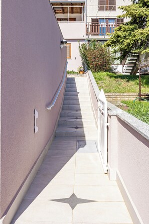 Stroll through the serene gardens to the entrance of this stylish building.