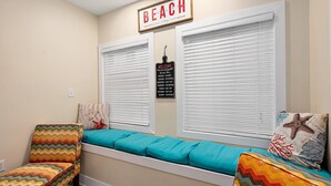 Ein Zimmer mit Fensterbank, einem Schild mit der Aufschrift 'BEACH', einem Schild mit der Aufschrift 'WELCOME' und einem an der Wand befestigten Kalender.