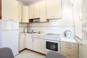 A compact kitchen with white cabinets, a built-in oven, and a sink. - Apartment 613/1468 (Istria - Pula), 500m from the beach (Pula)