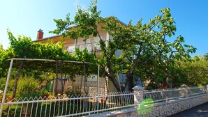 Un bâtiment avec un mur en pierre et une clôture blanche.
