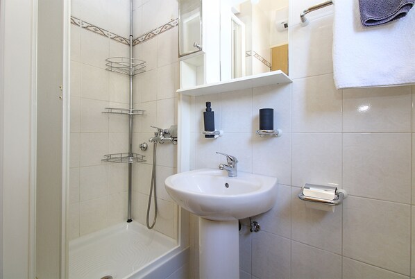 A bathroom with a bathtub, a sink, and a shower. - Apartment 613/1470 (Istria - Pula), 500m from the beach (Pula)