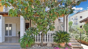 A building with a stone facade, a white door, and a balcony with a balustrade.