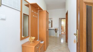 A hallway with wooden cabinets, a mirror, and a door leading to a bathroom.