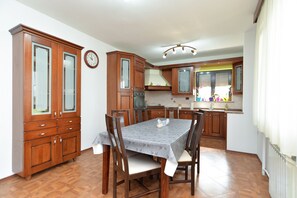 Enjoy meals in this kitchen with an oven, range hood, and dining table for four.