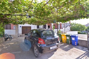Guests can park their vehicles under a shaded canopy near the hotel's garage.