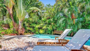 A poolside area with lounge chairs and a small pool, surrounded by lush tropical foliage. - Modern Oasis in Tropical Serene Victoria Park/Private Pool/Near Beach Las Olas (Fort Lauderdale)