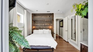 A bedroom with a wooden wall, a bed, and a plant. - Modern Oasis in Tropical Serene Victoria Park/Private Pool/Near Beach Las Olas (Fort Lauderdale)