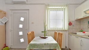 A kitchen with a dining table, chairs, a window with blinds, a radiator, and a sink. - Apartment 624/1489 (Istria - Pula), 2500m from the beach (Pula)