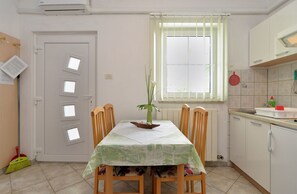 A kitchen with a dining table, chairs, a window with blinds, a radiator, and a sink. - Apartment 624/1489 (Istria - Pula), 2500m from the beach (Pula)