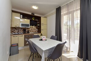 A compact kitchen with a dining area, featuring a tiled backsplash, a microwave, and a coffee maker. - Apartment 628/1500 (Istria - Valbandon), 500m from the beach (Valbandon)