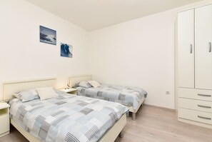 A bedroom with two beds, a wardrobe, and two wall-mounted pictures. - Apartment 628/1501 (Istria - Valbandon), 500m from the beach (Valbandon)