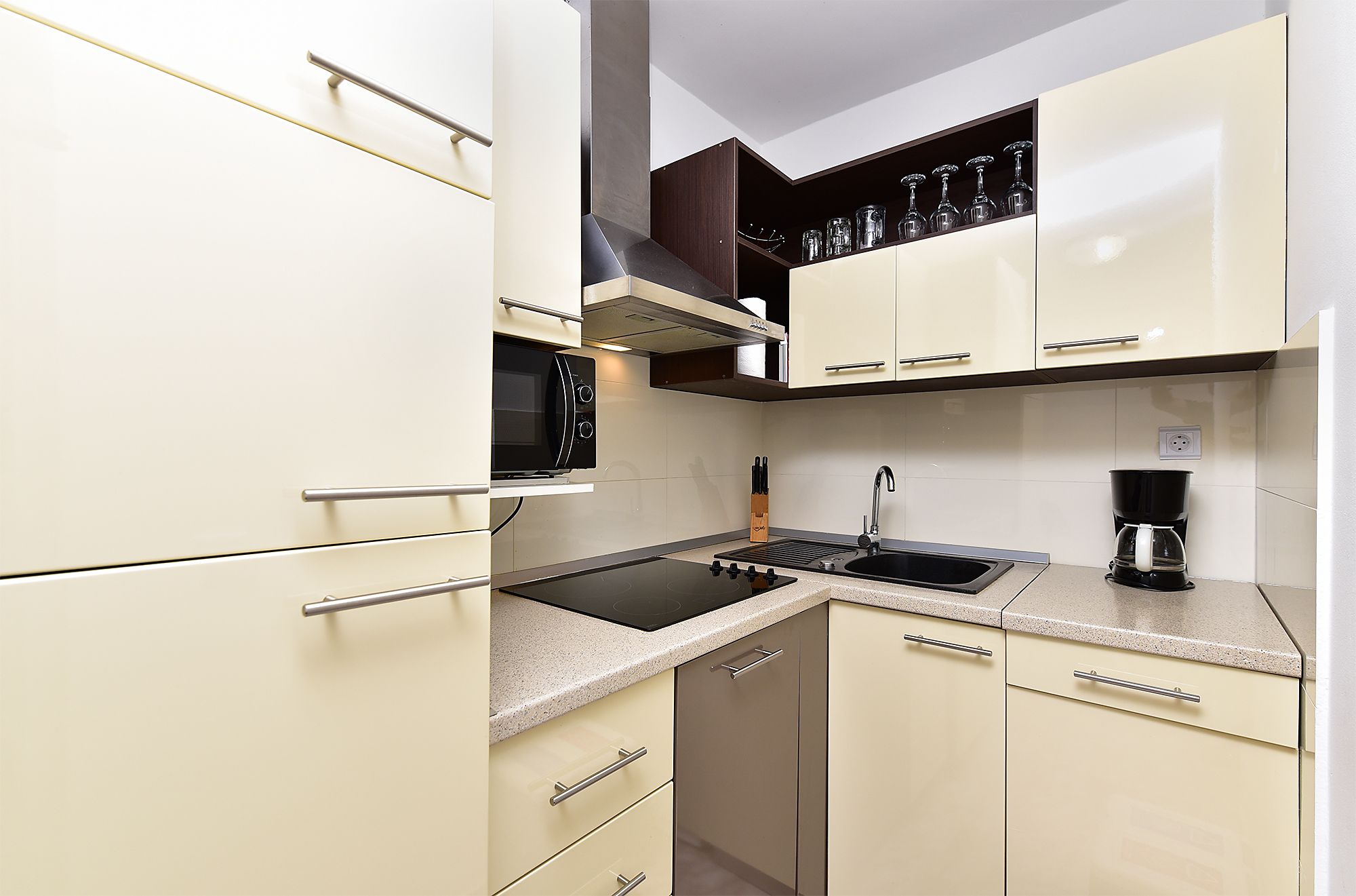 A kitchen with a microwave, sink, and coffee maker.
