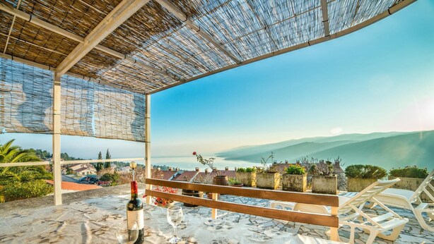 An outdoor seating area with a table, chairs, and a bottle of wine. - Apartment 629/26308 (Istria - Rabac), 750m from the beach (Rabac)