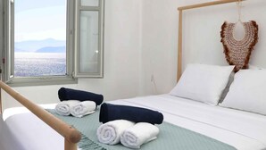 Ein Hotelzimmer mit Bett, Meerblick und Klimaanlage.