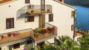 Un immeuble doté de nombreux balcons, d’une cheminée et offrant une vue sur la mer.