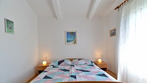 A bedroom with a bed, two bedside tables, and a wall-mounted picture. - Apartment 667/1581 (Istria - Medulin), 300m from the beach (Medulin)