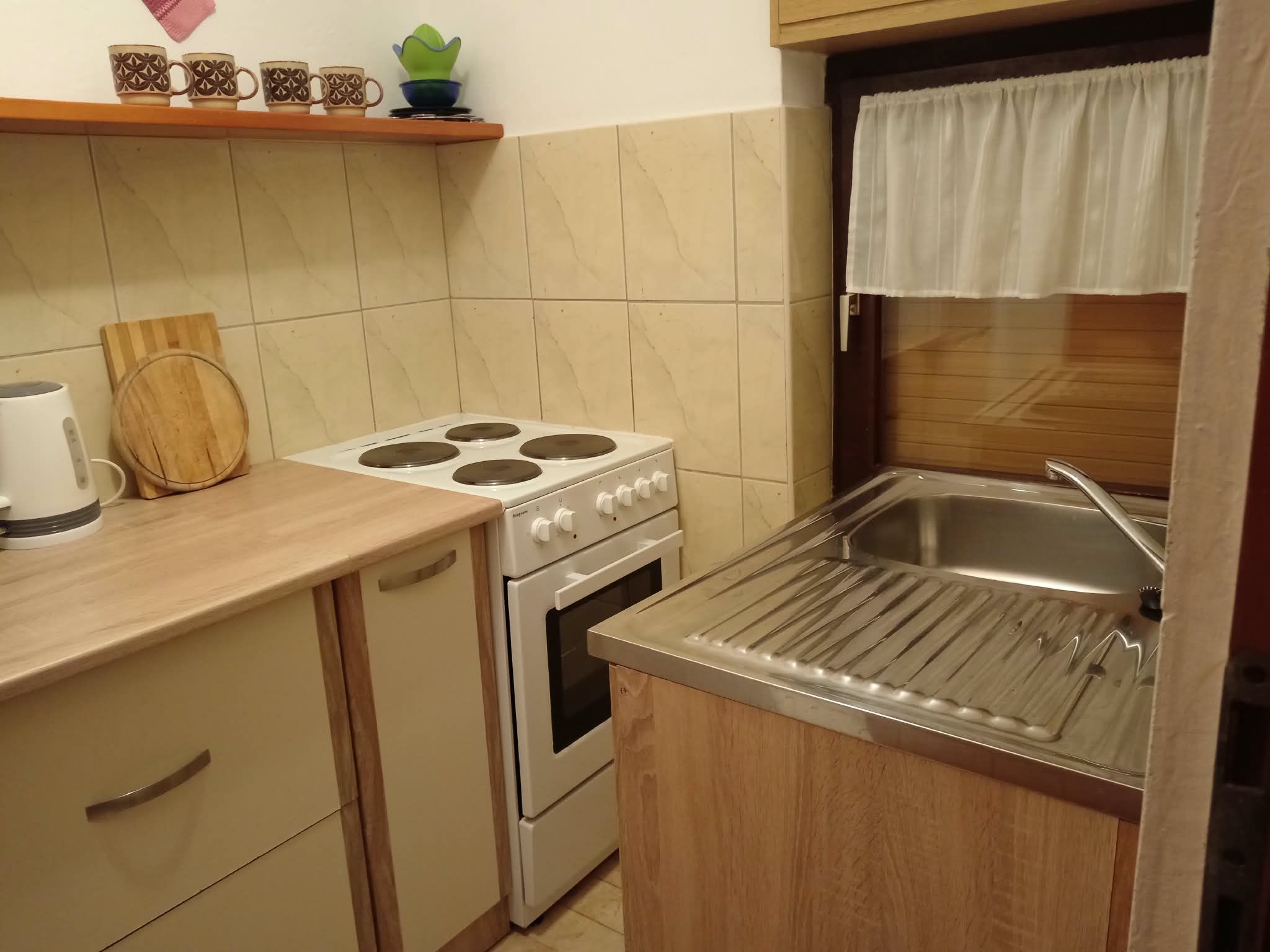 A compact kitchen with a stove, oven, and sink.