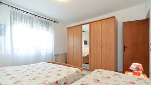 A bedroom with two beds, a wardrobe, and a bedside lamp. - Apartment 684/1615 (Istria - Stinjan), 400m from the beach (Stinjan)