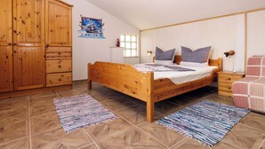 A bedroom with a wooden bed, a wardrobe, a poster on the wall, and a window. - Apartment 692/1629 (Istria - Premantura), 450m from the beach (Premantura)