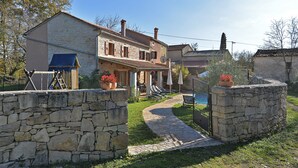 A stone-walled property with a paved pathway leading to a house with a tiled roof and a balcony. - Villa 704/1643 (Istria - Žminj), 25000m from the beach (Žminj)