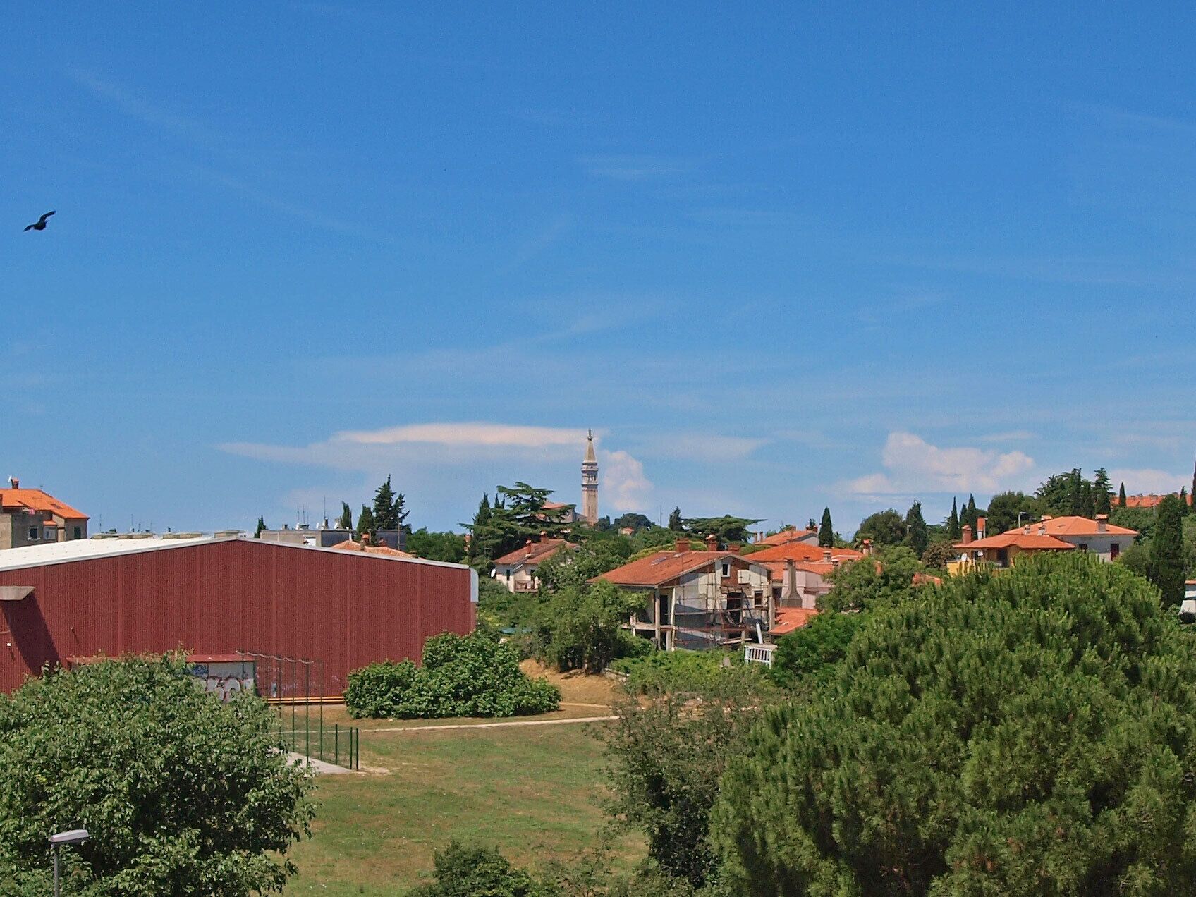 A residential area with houses, a tall tower, and a clear blue sky.