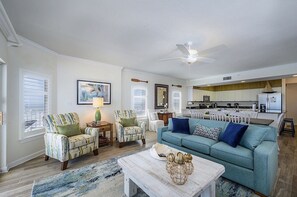 A living room with a sofa, chairs, a coffee table, and a ceiling fan. - Luxury Beachfront 4BR/4BA Condo Sleeps 13 with Stunning Views and Large Balcony (Orange Beach)