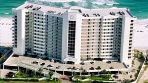 A high-rise hotel with multiple floors, a central courtyard, and a beach view. - Luxury Beachfront 4BR/4BA Condo Sleeps 13 with Stunning Views and Large Balcony (Orange Beach)